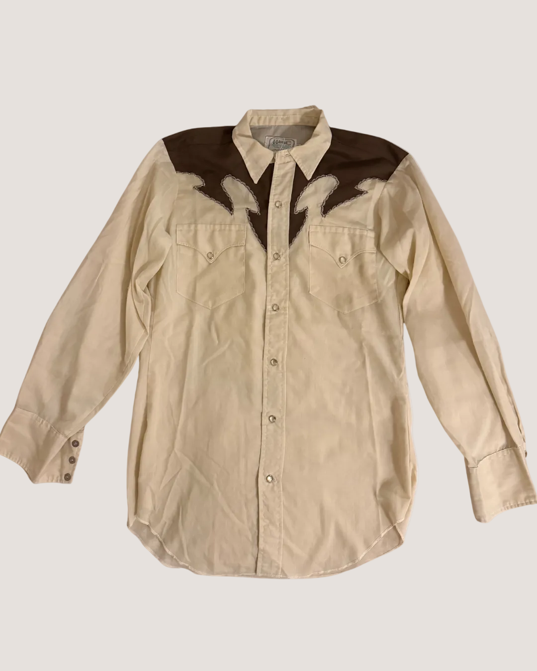 Beige shirt with brown accents on a light gray background