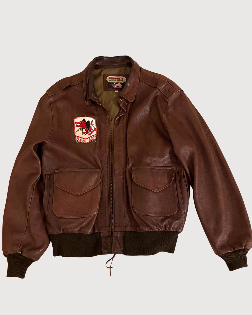 Brown A2 leather jacket with a patch on a white background