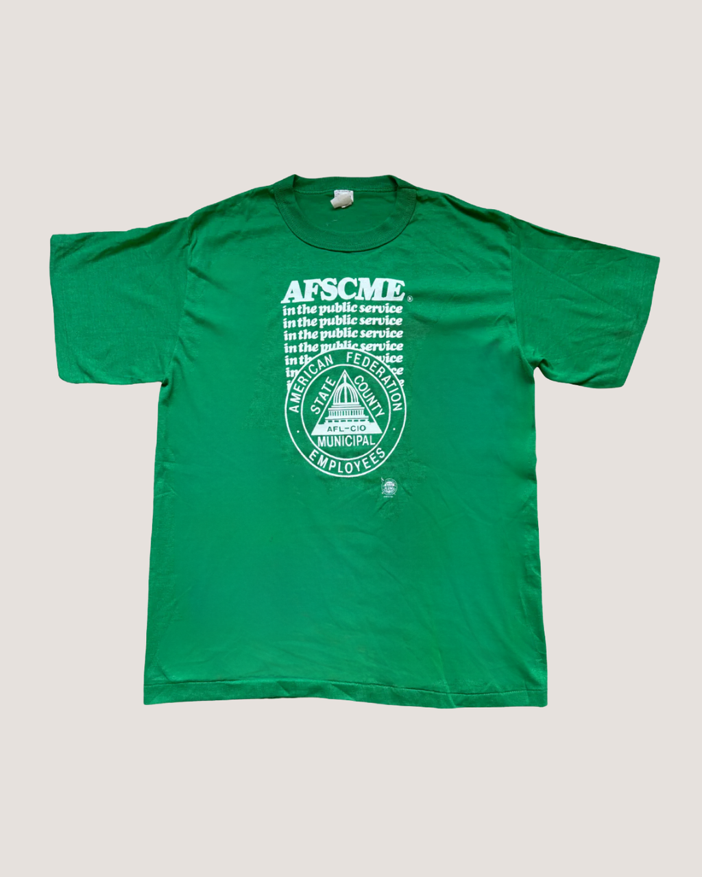 Green t-shirt with AFSCME logo on a light gray background