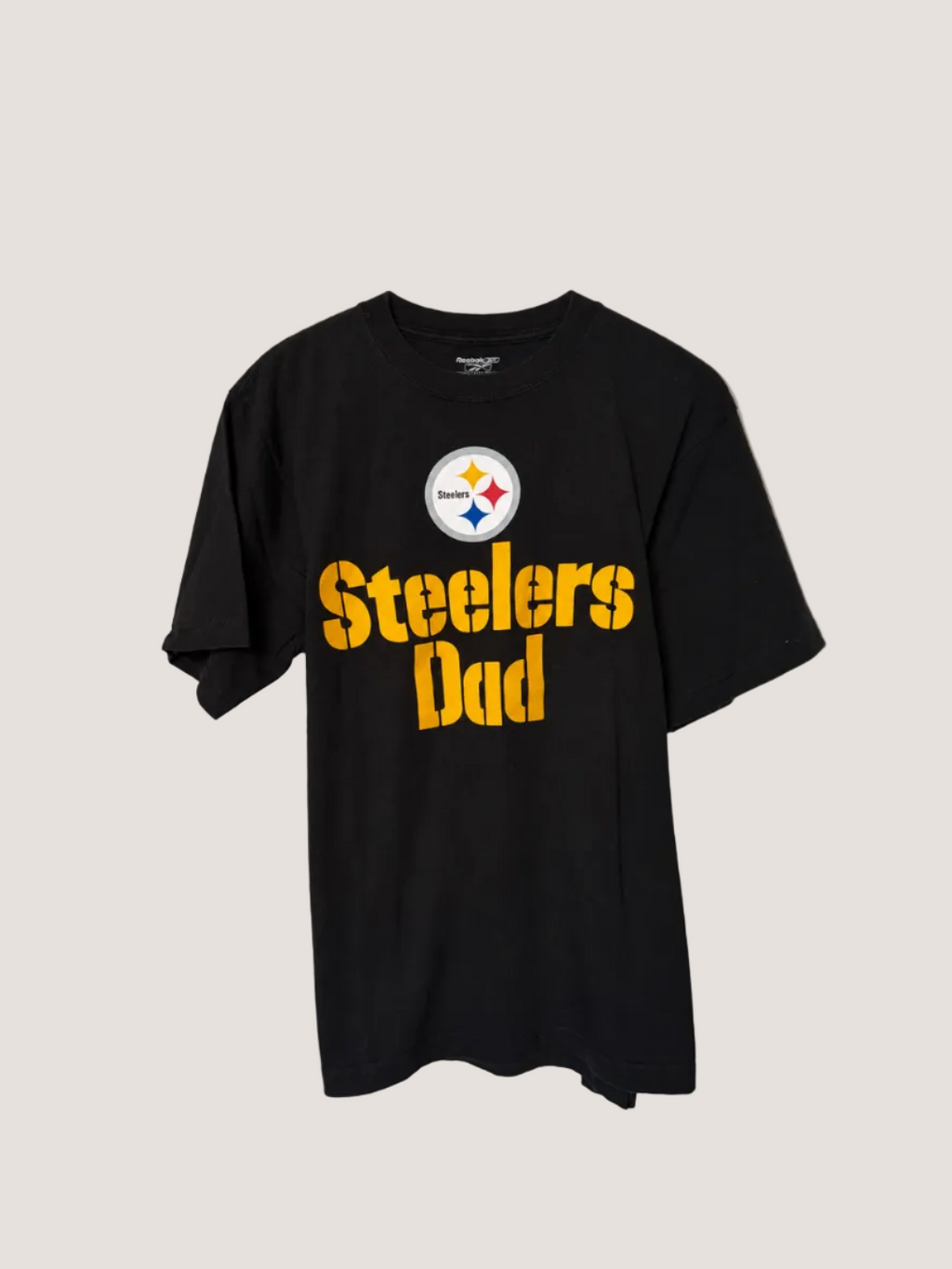 Black t-shirt with Steelers Dad text and logo on a plain background