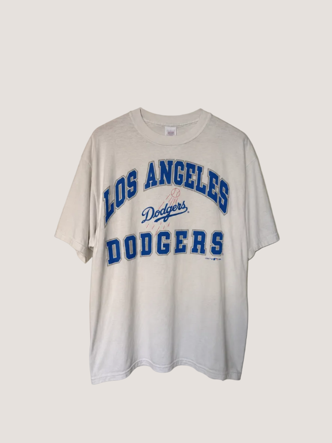 White t-shirt with 'Los Angeles Dodgers' text on a beige background