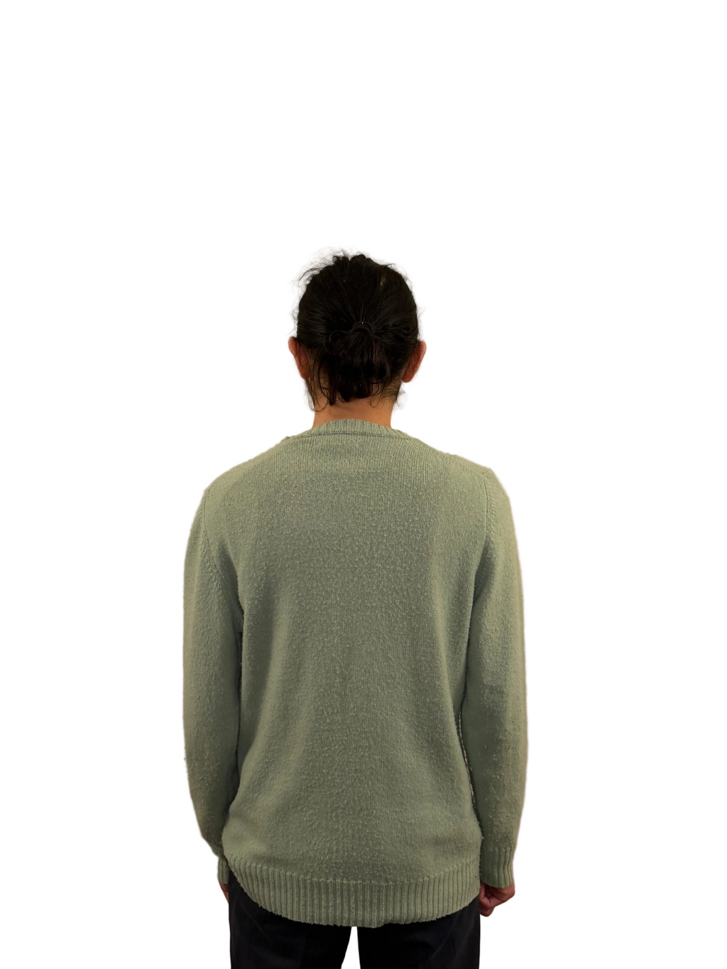 Person wearing a green sweater against a plain background