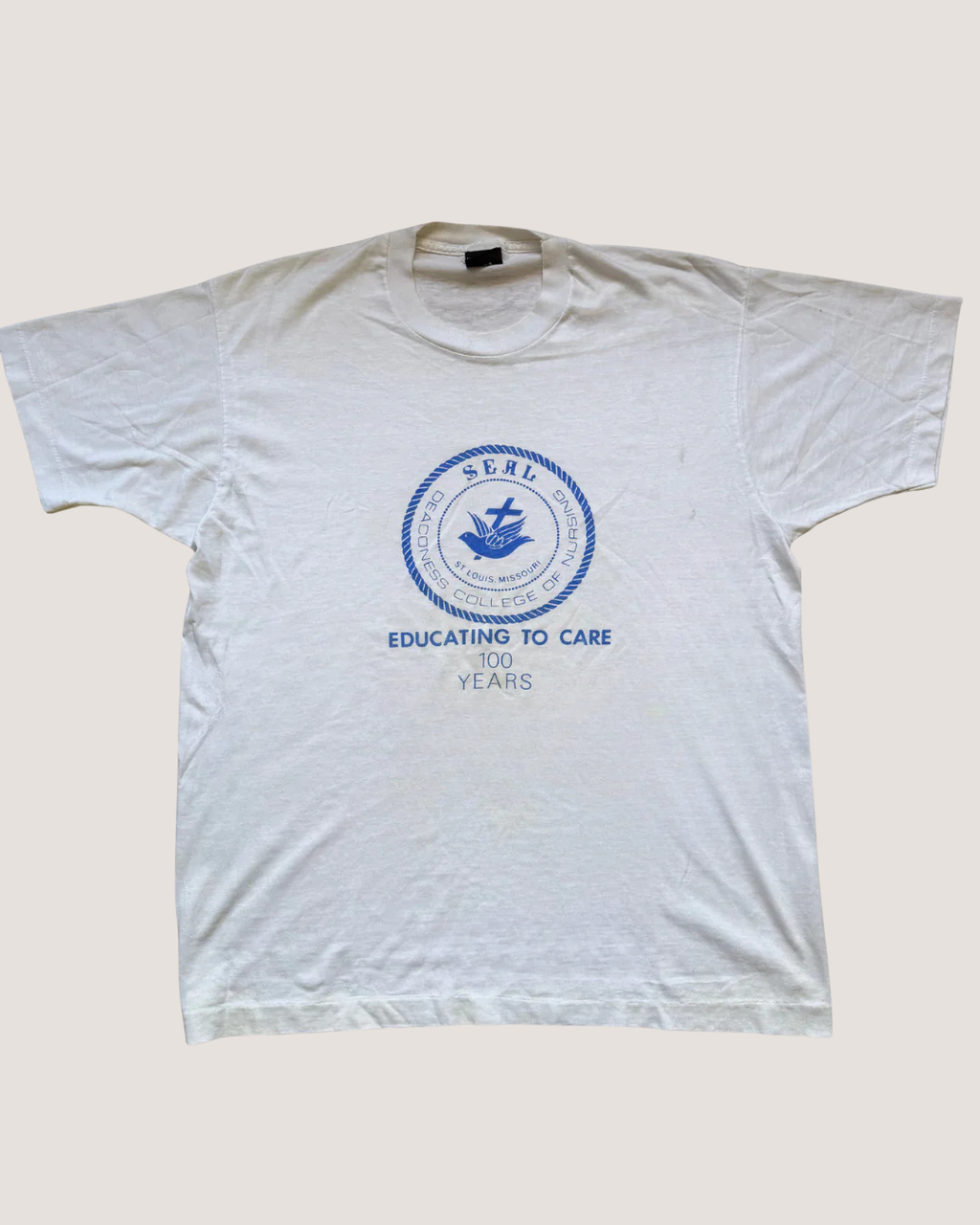 White seal t-shirt with blue logo and text on a light gray background