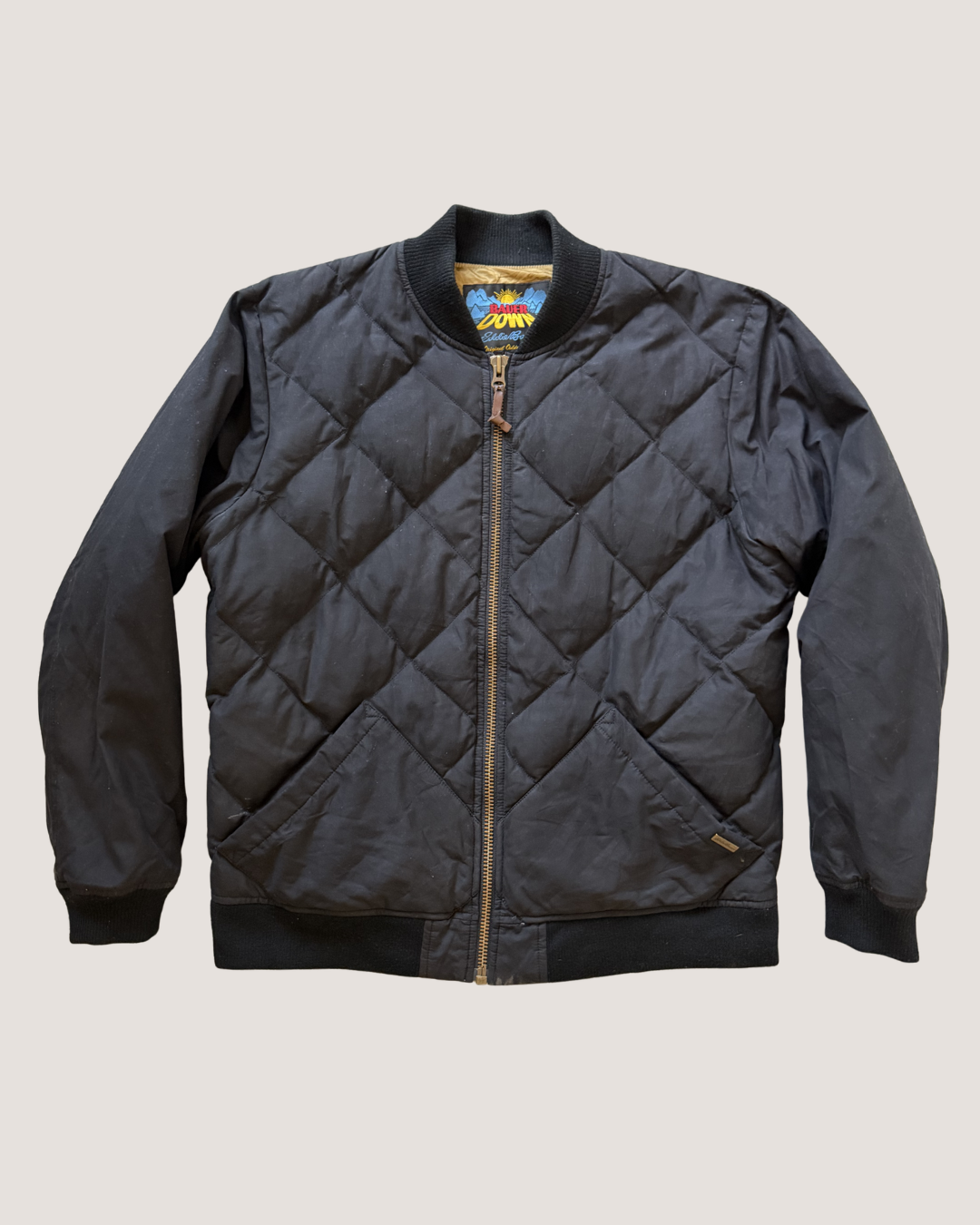 Quilted jacket with brand logo on a light gray background